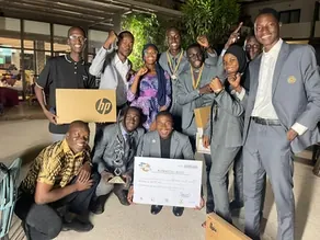 Équipe d’étudiants célébrant sa victoire à une compétition inter-universitaire de débat, chèque et ordinateur portable remis en récompense.